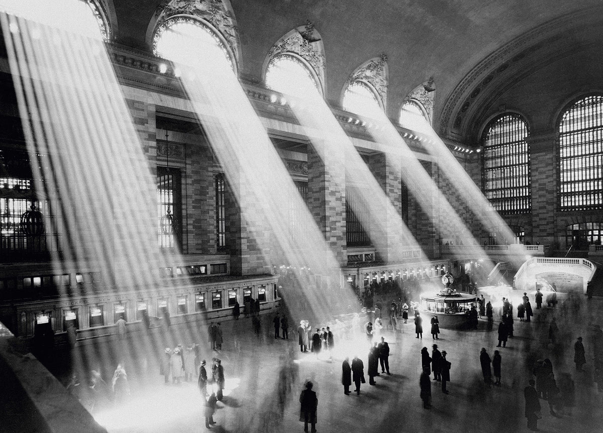 Black and white photograph of dramatic beams of sunlight streaming through the windows of Grand Central Station, New York, circa 1930