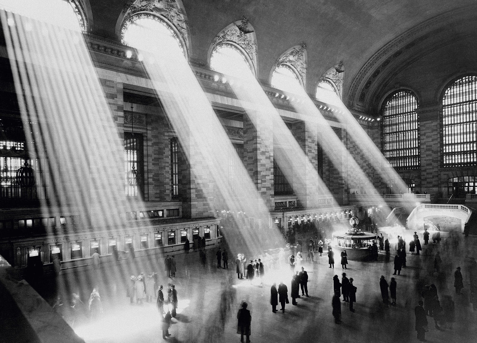 Black and white photograph of dramatic beams of sunlight streaming through the windows of Grand Central Station, New York, circa 1930