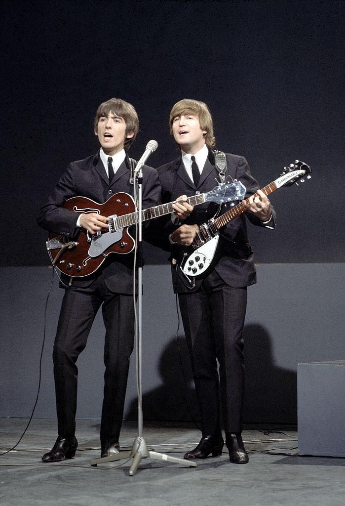 Colour photograph of George Harrison and John Lennon playing guitars side by side on stage for the TV show Shindig!, London, 1964