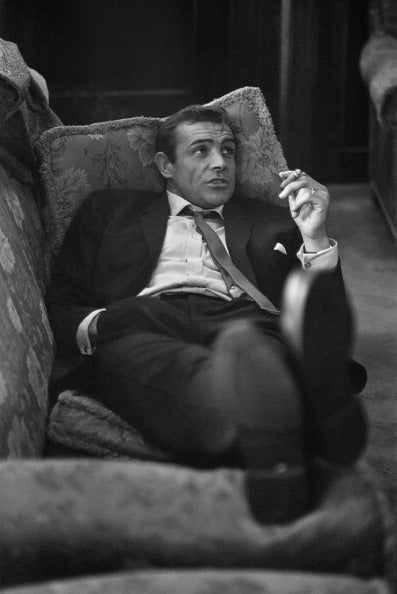 Sexy Scot by Bob Haswell/Getty Images, 1963. British actor Sean Connery lounges on a sofa with a cigarette.. Open Edition Resin Photographic Print. Portrait orientation. Available at Electric Gallery, London, UK.
