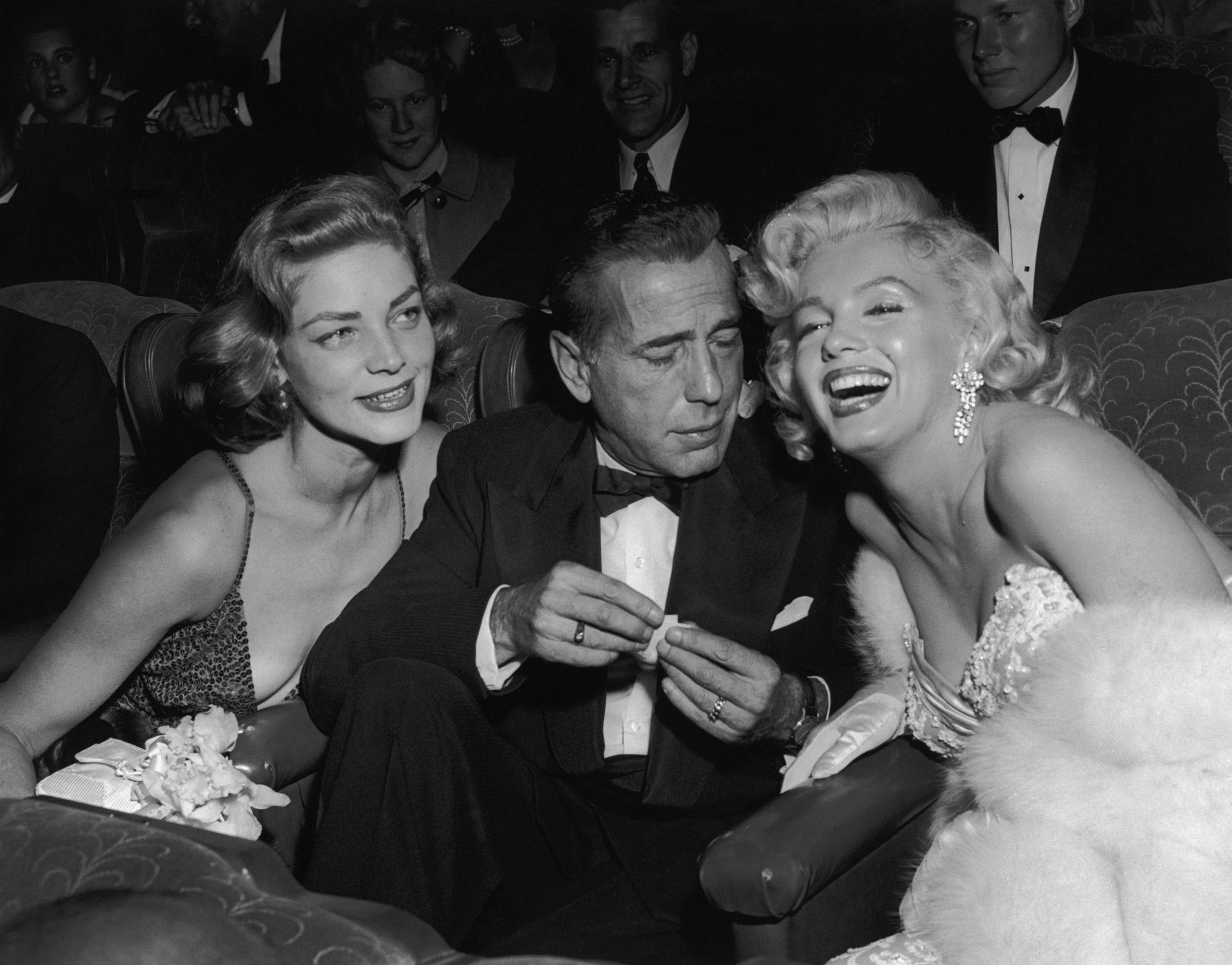 Star Trio by Darlene Hammond/Getty Images, 1953. Married American actors Lauren Bacall and Humphrey Bogart pose with American actor Marilyn Monroe at the premiere of director Jean Negulesco's film, 'How to Marry a Millionaire'.. Open Edition Resin Photographic Print. Landscape orientation. Available at Electric Gallery, London, UK.