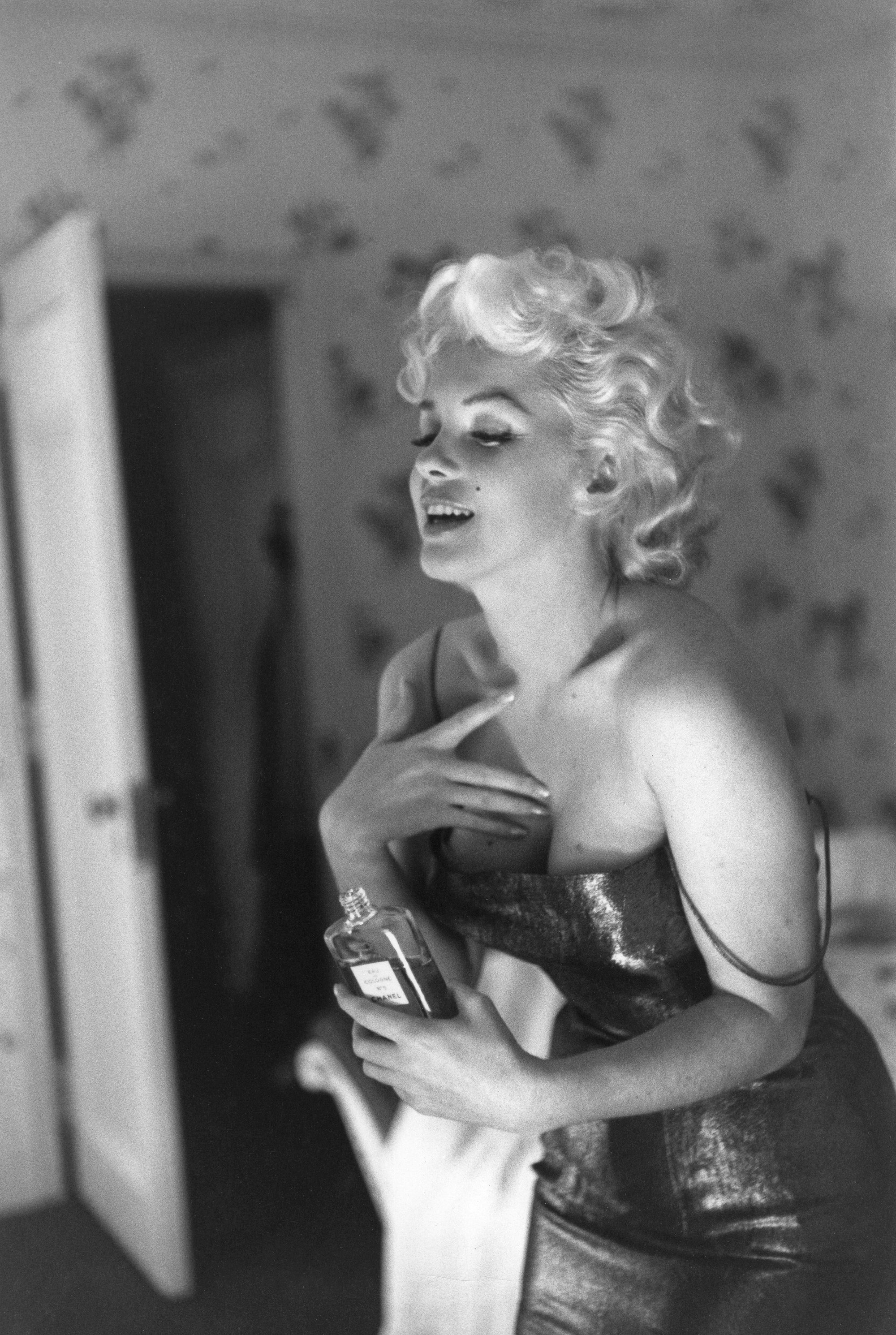 Marilyn Getting Ready To Go Out by Ed Feingersh/Getty Images, 1955. Actress Marilyn Monroe gets ready to go see the play "Cat On A Hot Tin Roof" playfully applying her make up and Chanel No.. Open Edition Resin Photographic Print. Landscape orientation. Available at Electric Gallery, London, UK.