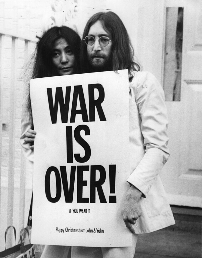 War Is Over by Frank Barratt/Getty Images, 1969. John Lennon and Yoko Ono pose on the steps of the Apple building in London, holding one of the posters that they distributed to the world's major cities as part of a peace campaign protesting against the Vietnam War.. Open Edition Resin Photographic Print. Portrait orientation. Available at Electric Gallery, London, UK.
