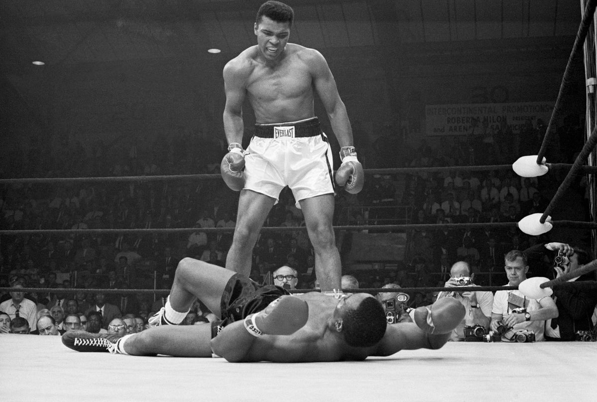 Black and white photograph of Muhammad Ali standing over a floored Sonny Liston in the boxing ring at Lewiston, Maine, 1965