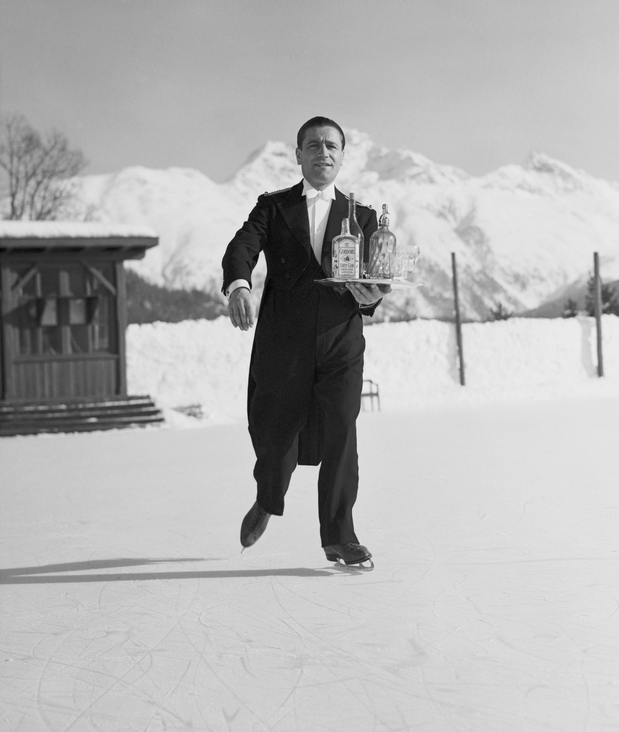 Skating Waiter by Horace Abrahams/Getty Images, 1938. A waiter skates across the ice at St.. Open Edition Resin Photographic Print. Portrait orientation. Available at Electric Gallery, London, UK.