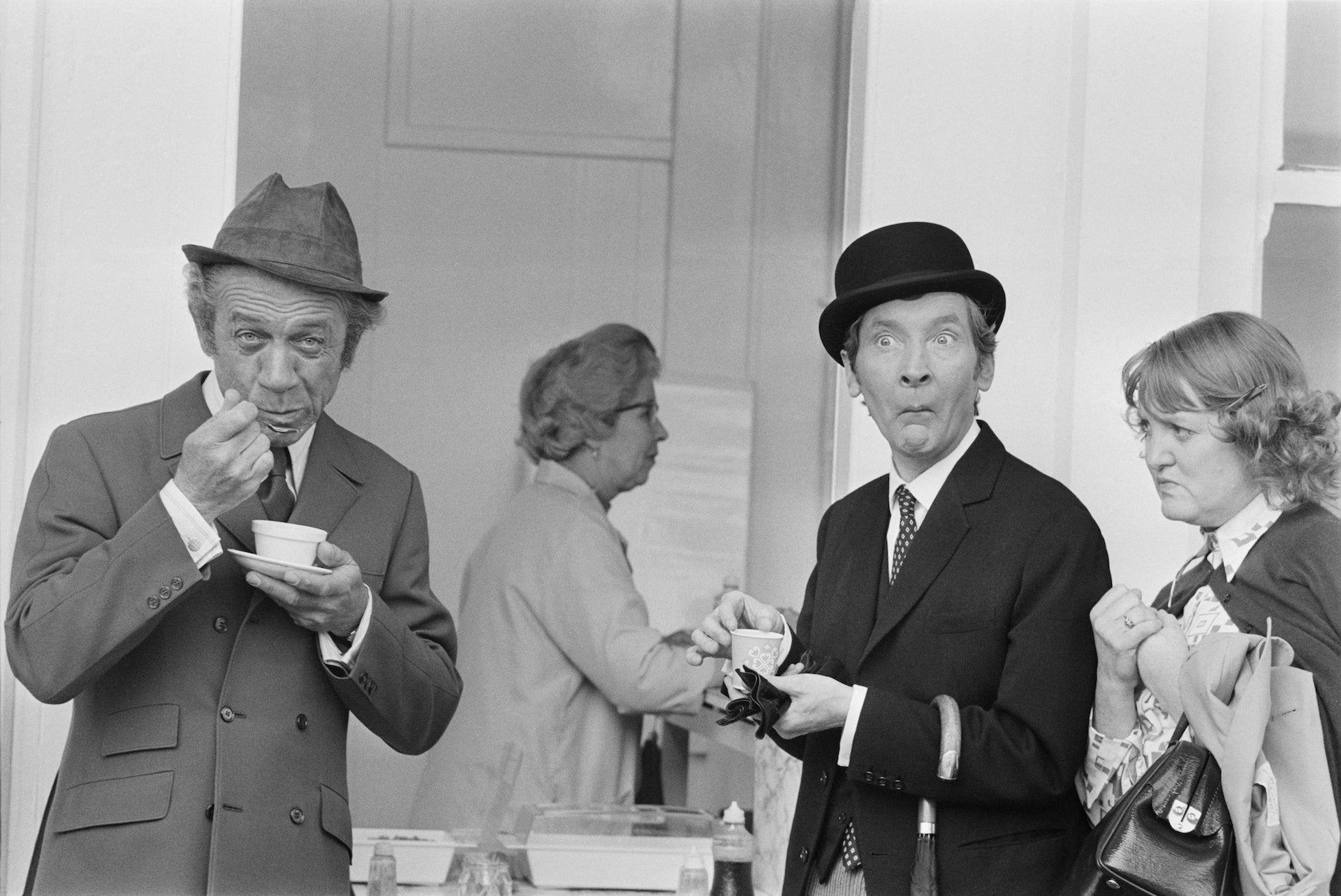 Carry on Tea Break by Larry Ellis/Getty Images, 1971. British actors Sid James and Kenneth Williams eating jellied eels from paper cups during the filming of 'Carry On At Your Convenience'. Open Edition Resin Photographic Print. Landscape orientation. Available at Electric Gallery, London, UK.