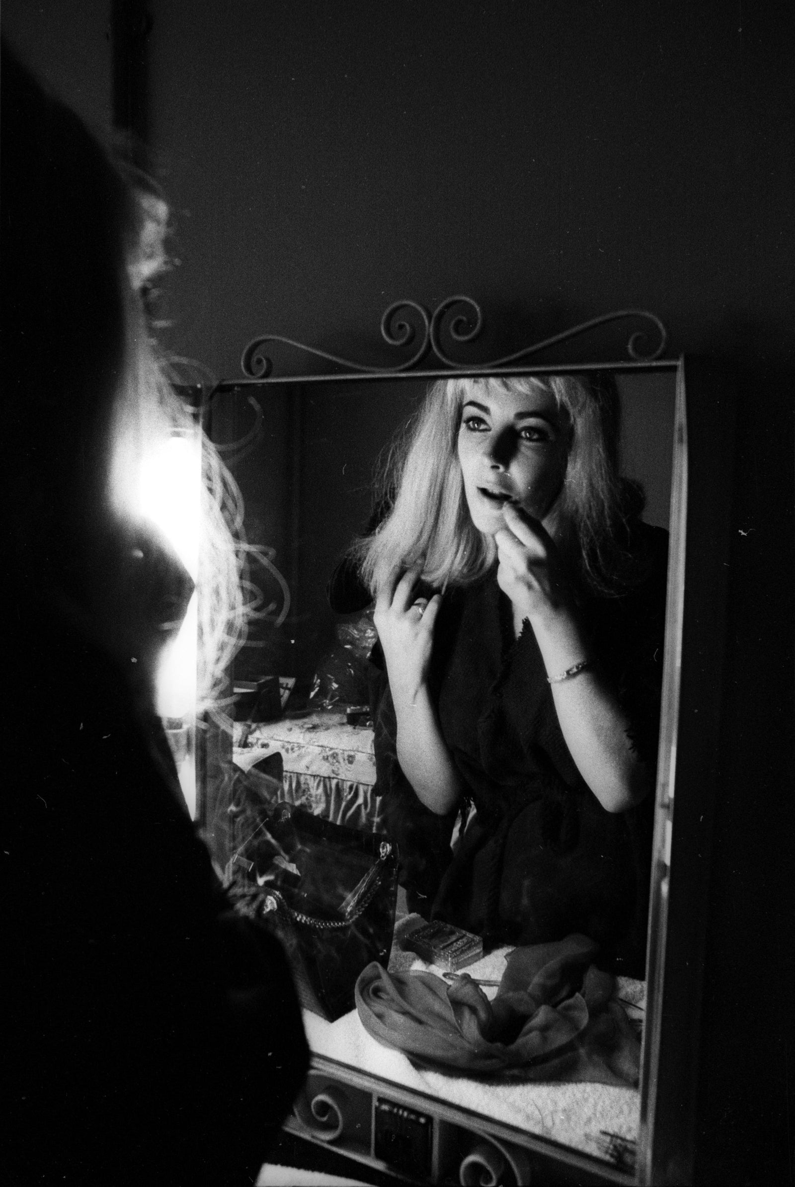 Liz Taylor Portrait Session In Blonde Wig by Michael Ochs/Getty Images, 1963. Actress Elizabeth Taylor poses for a portrait session wearing a blonde wig while fixing her make-up and hair in. Open Edition Resin Photographic Print. Portrait orientation. Available at Electric Gallery, London, UK.