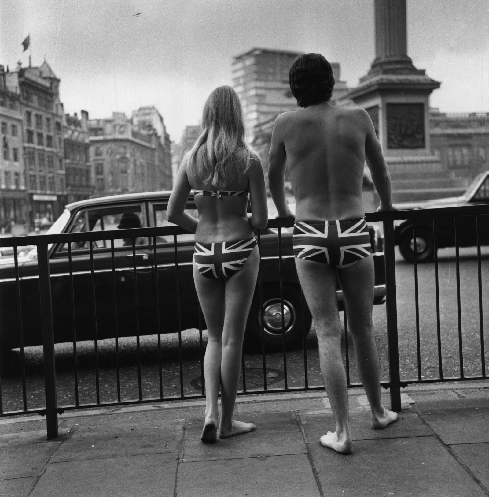 Union Jack Trunks by Michael Webb/Getty Images, 1969. Two models in Union Jack swimwear posing in Trafalgar Square to promote tourism to Gibraltar, 23rd. Open Edition Resin Photographic Print. Square orientation. Available at Electric Gallery, London, UK.