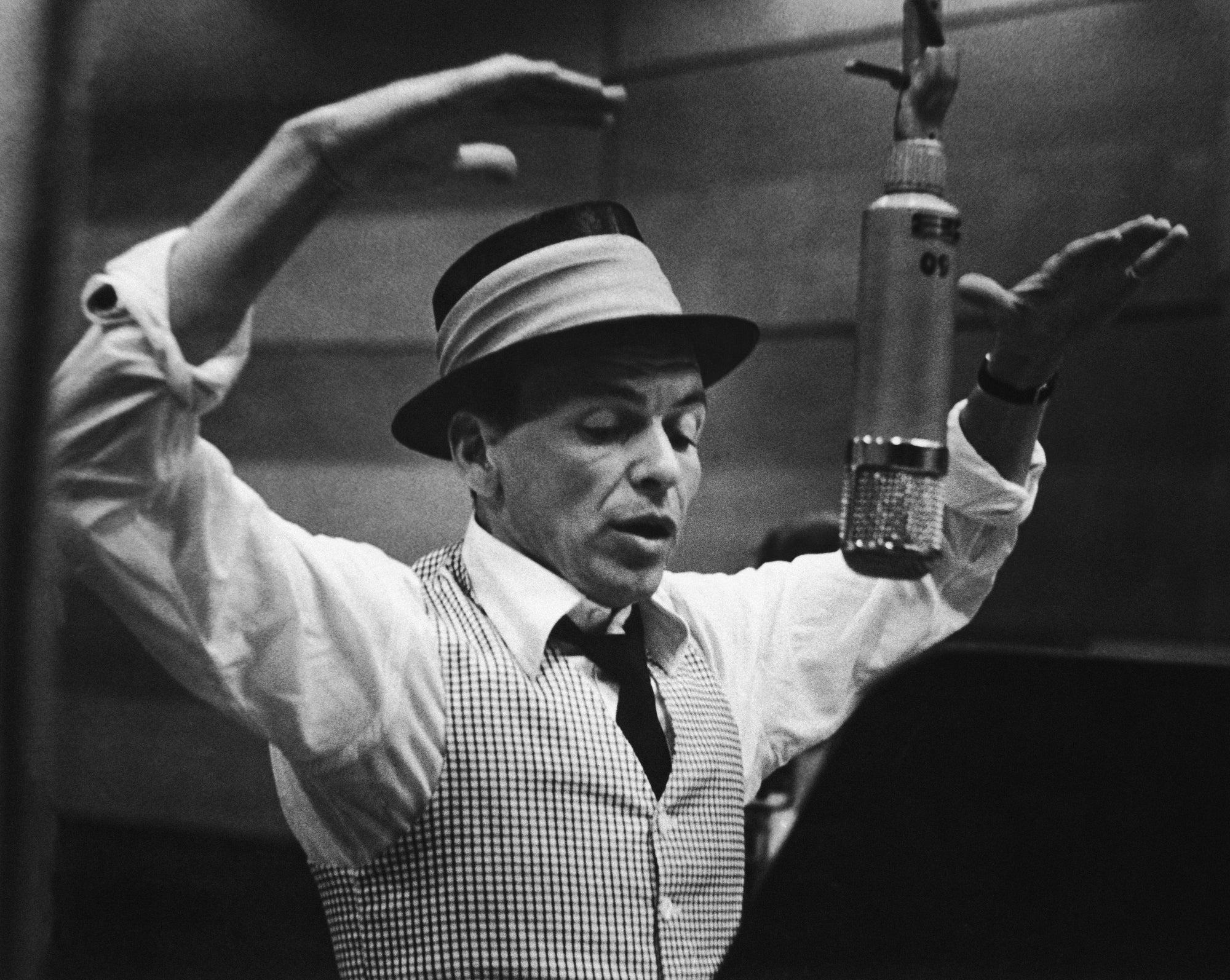 Frank Sinatra Recording Session by Murray Garrett/Getty Images, 1950. American singer and actor Frank Sinatra gestures with his hands while singing into a microphone during a recording session in a studio at Capitol Records, early. Open Edition Resin Photographic Print. Portrait orientation. Available at Electric Gallery, London, UK.