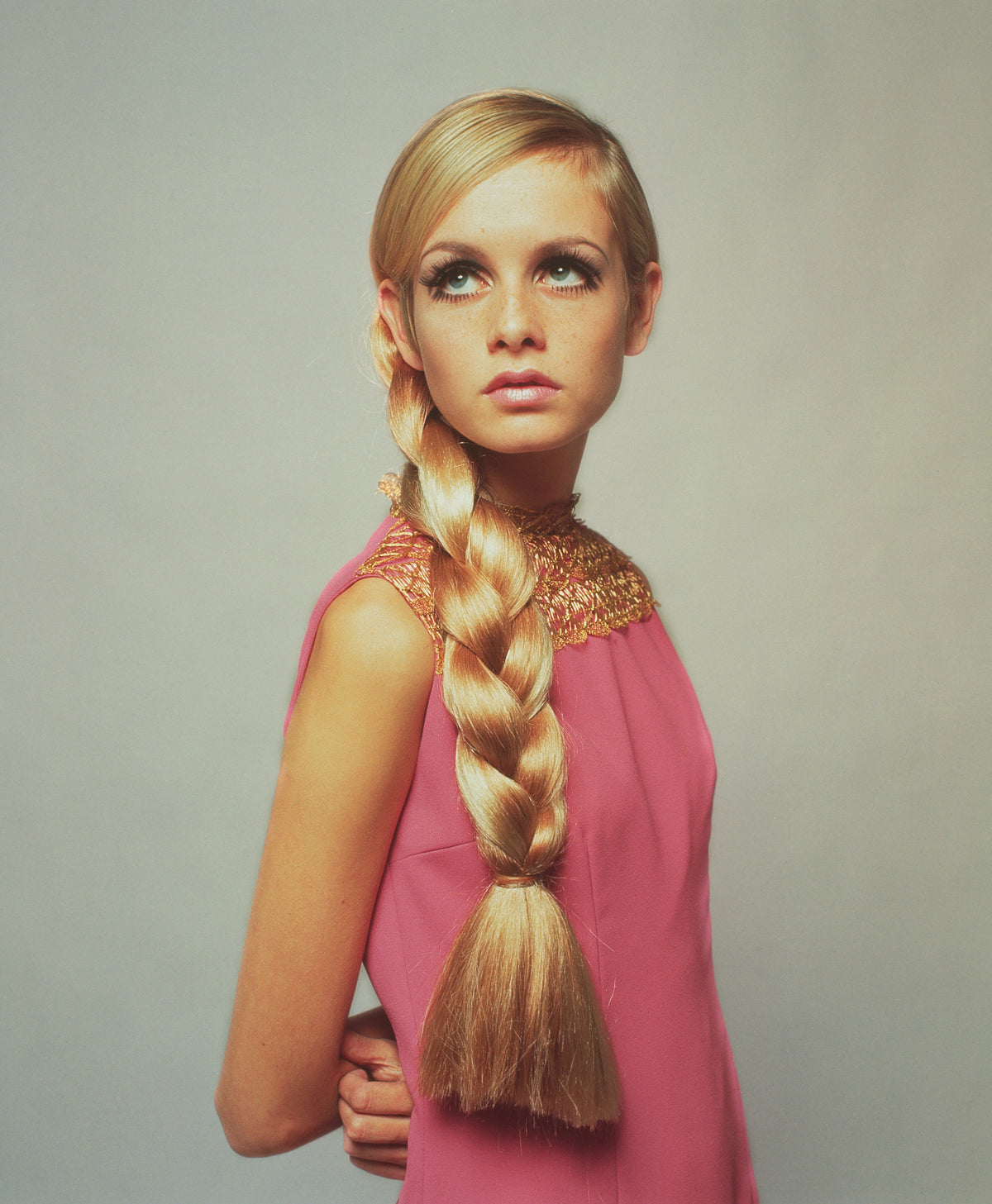 Twiggy In Pink by Popperfoto/Getty Images, 1966. A portrait of model Twiggy wearing a fashionable pink dress and a large plait in her long hair.. Open Edition C-Type Photographic Print. Portrait orientation. Available at Electric Gallery, London, UK.