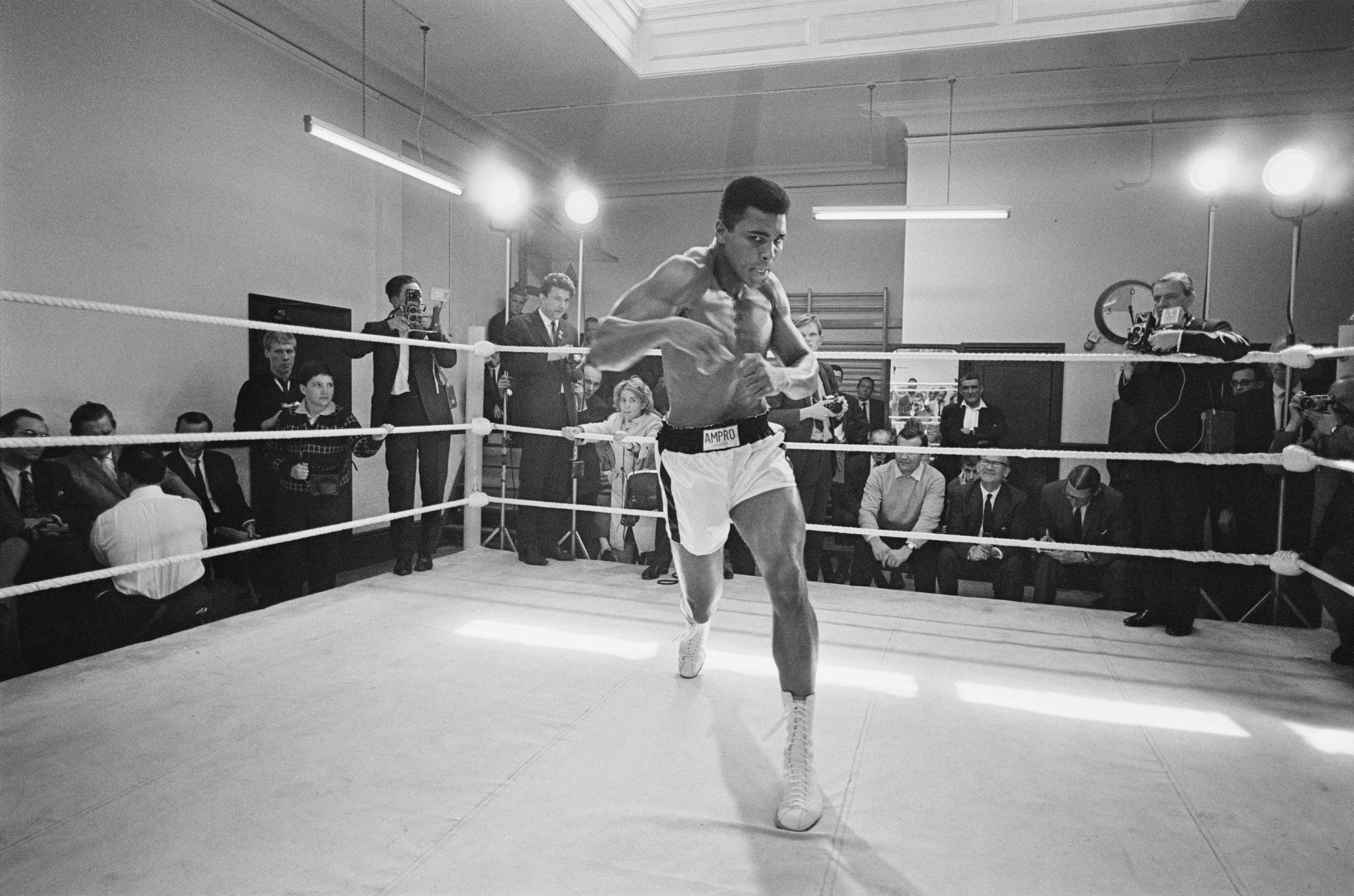 Ali In Training by Russell McPhedran/Getty Images, 1966. American heavyweight boxer Muhammad Ali throws bare-handed punches in the ring while in training for his fight against Brian London, London, England. Open Edition Resin Photographic Print. Landscape orientation. Available at Electric Gallery, London, UK.