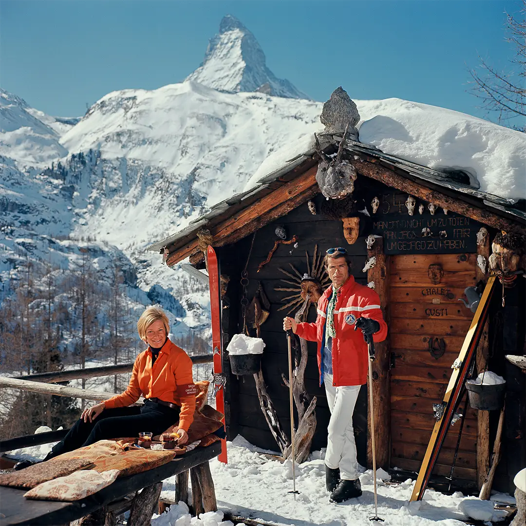 Chalet Costi by Slim Aarons/Getty Images, 1968. Skiers outside the Chalet Costi in Zermatt. Open Edition C-Type Photographic Print. Square orientation. Available at Electric Gallery, London, UK.