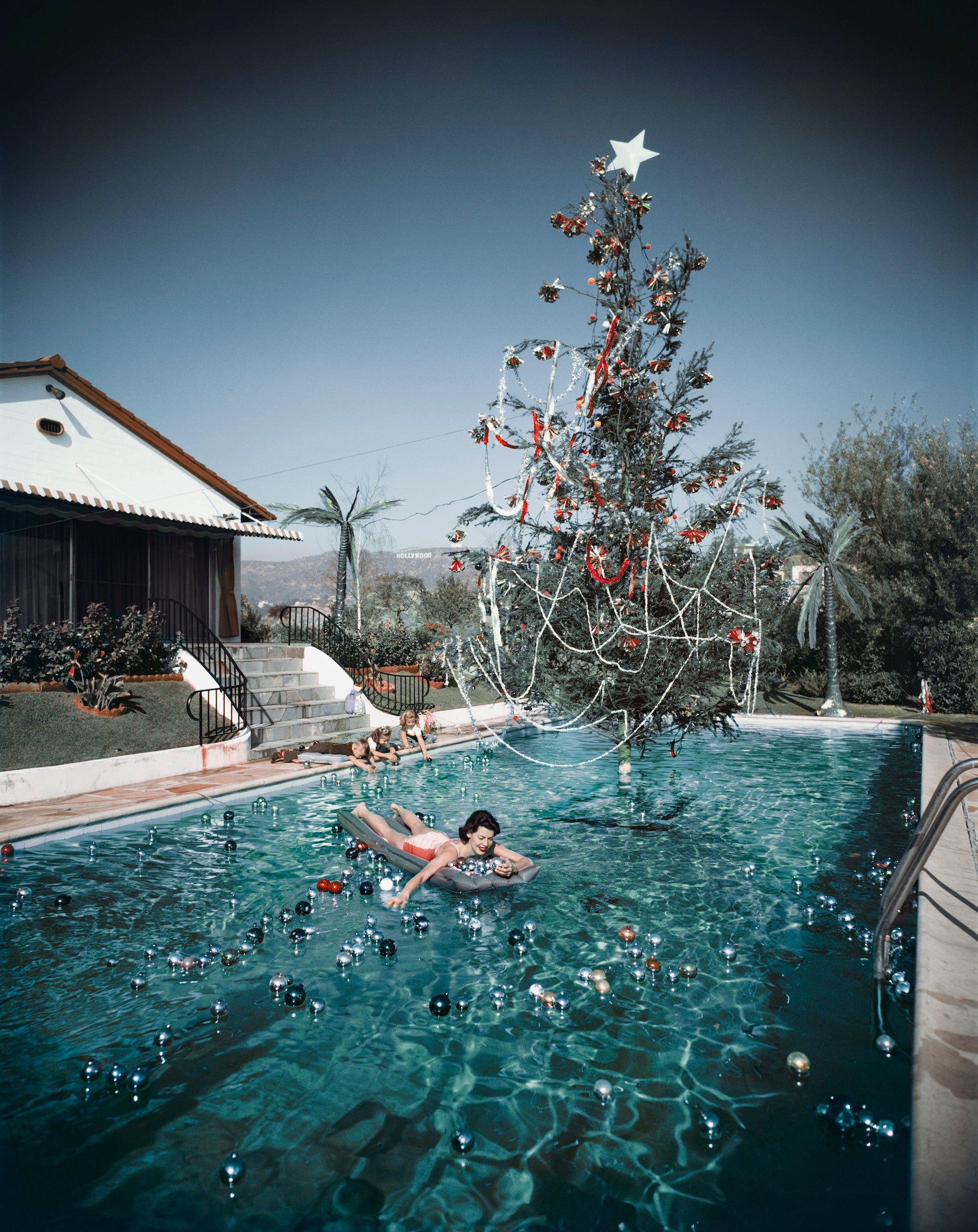 Christmas Swim by Slim Aarons/Getty Images, 1954. Open Edition C-Type Photographic Print. Portrait orientation. Available at Electric Gallery, London, UK.