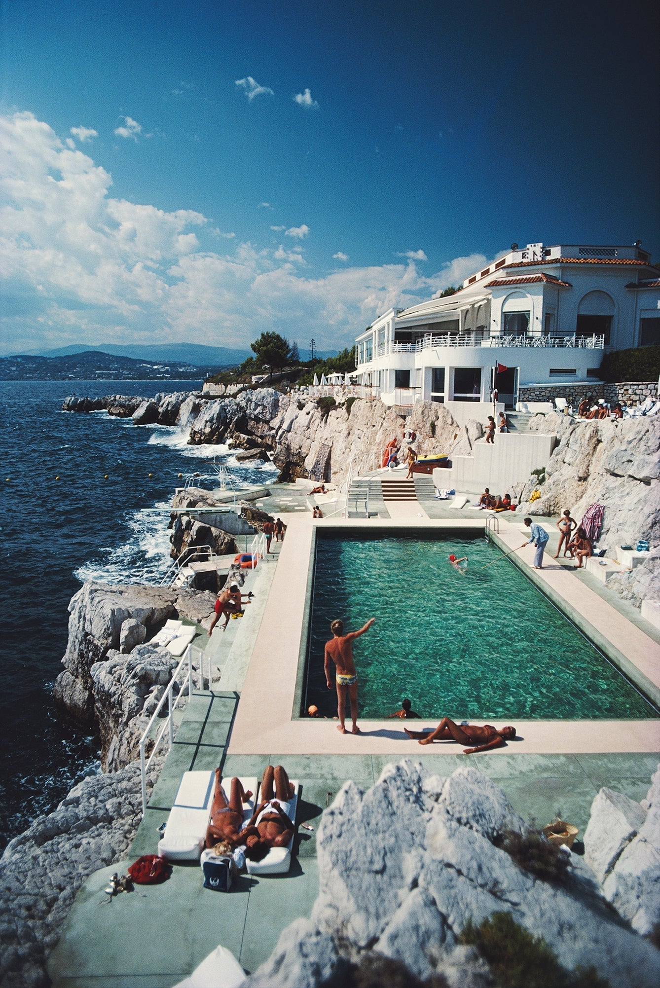 Eden - Roc Pool by Slim Aarons/Getty Images. Guests round the swimming pool at the Hotel du Cap Eden-Roc, Antibes, France. Available at Electric Gallery, London, UK.