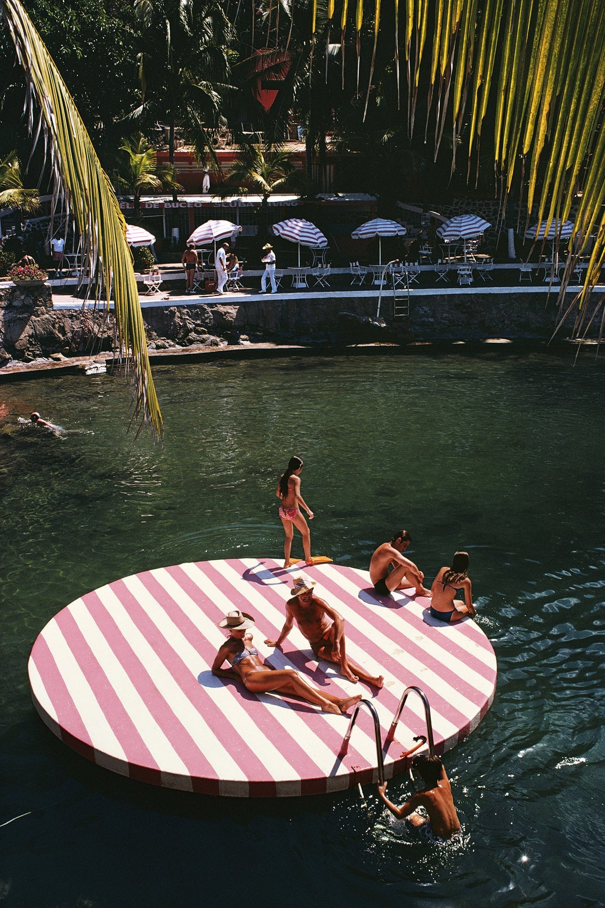 La Concha Beach Club by Slim Aarons/Getty Images, 1975. Bathers at La Concha Beach Club, Acapulco, Mexico. Open Edition C-Type Photographic Print. Portrait orientation. Available at Electric Gallery, London, UK.