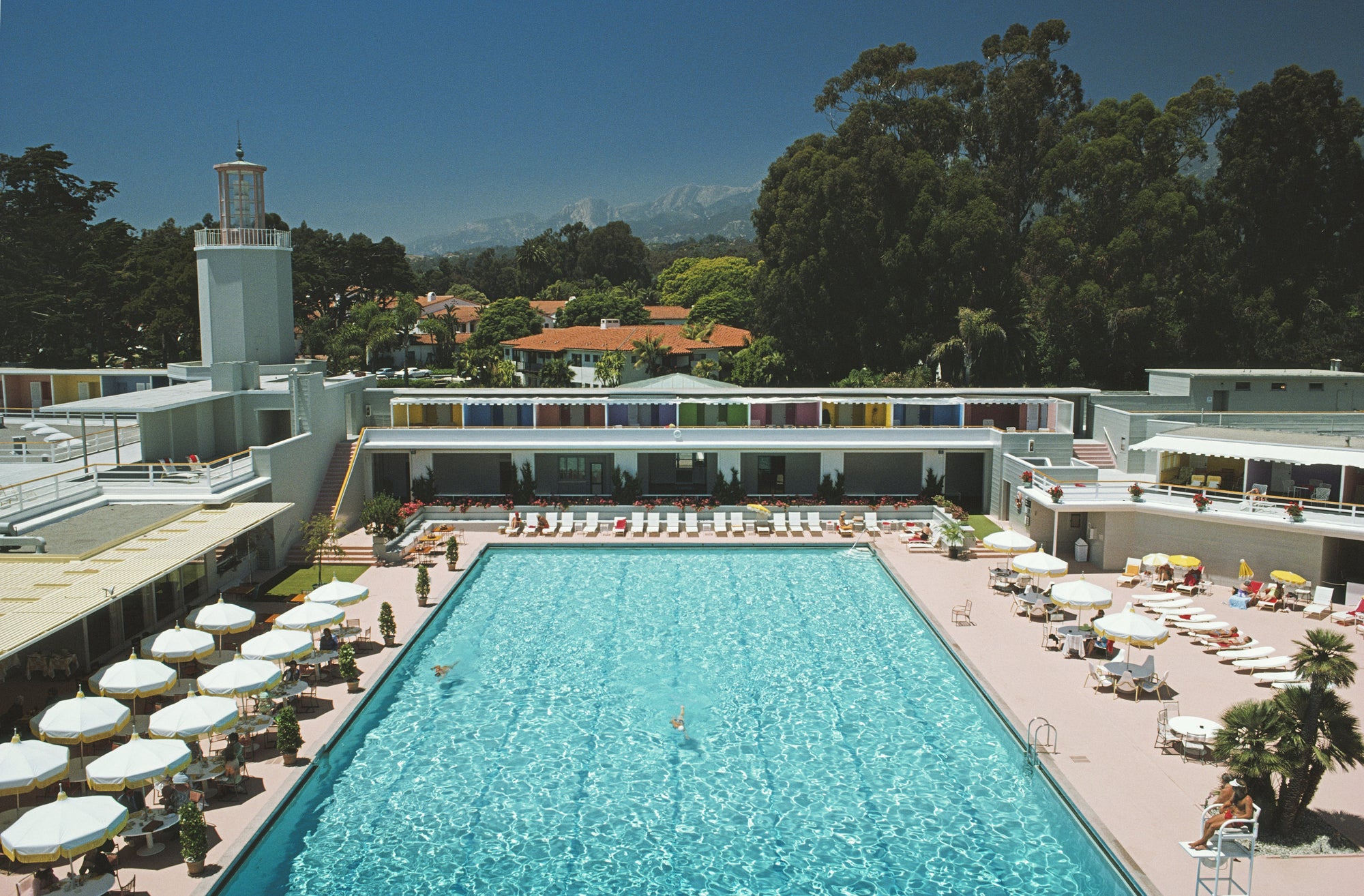 Monte Carlo Pool by Slim Aarons/Getty Images, 1965. White umbrellas line a swimming pool in Monte Carlo. Open Edition C-Type Photographic Print.. Landscape orientation. Available at Electric Gallery, London, UK.