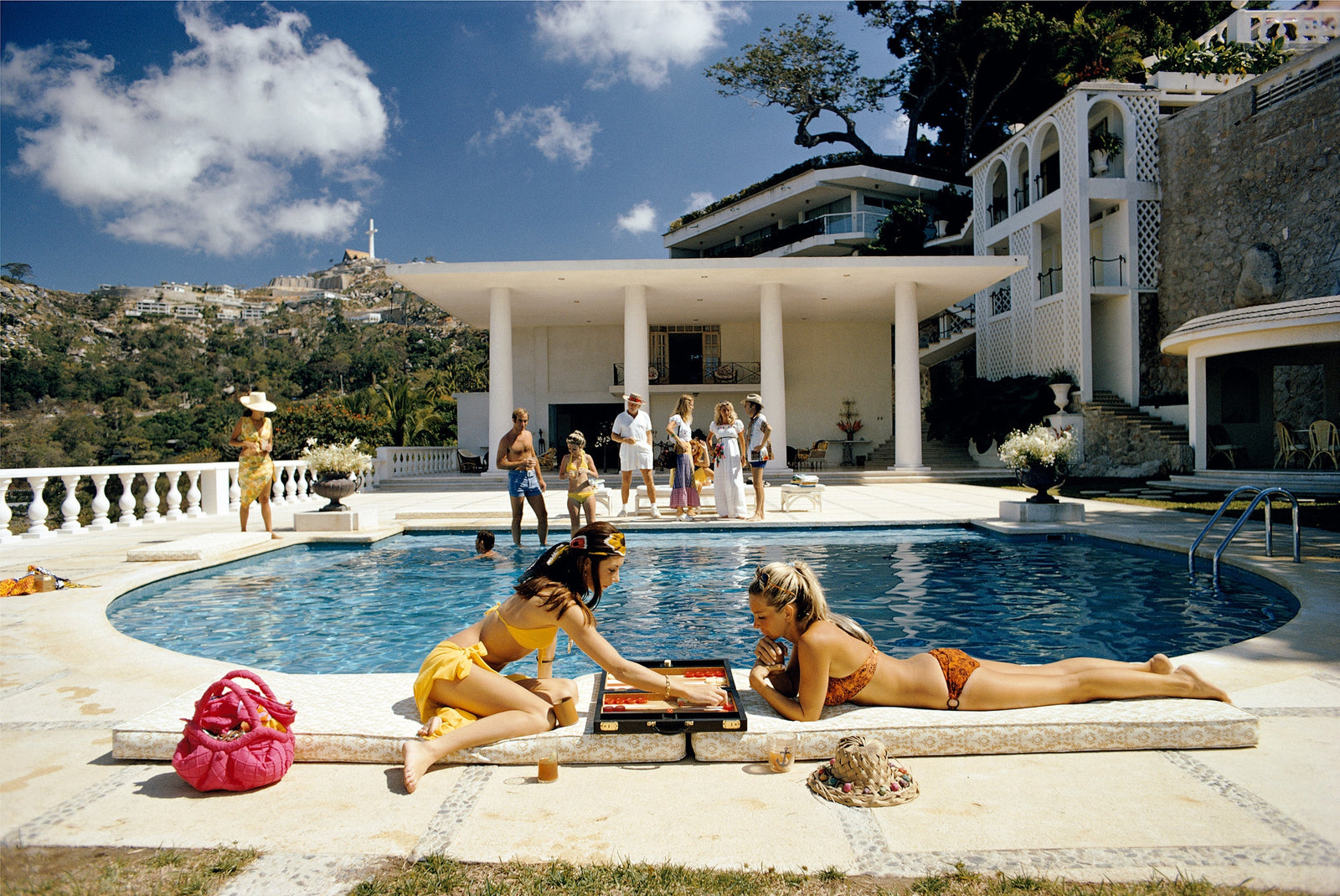 Poolside Backgammon by Slim Aarons/Getty Images, 1972. Open Edition C-Type Photographic Print. Landscape orientation. Available at Electric Gallery, London, UK.
