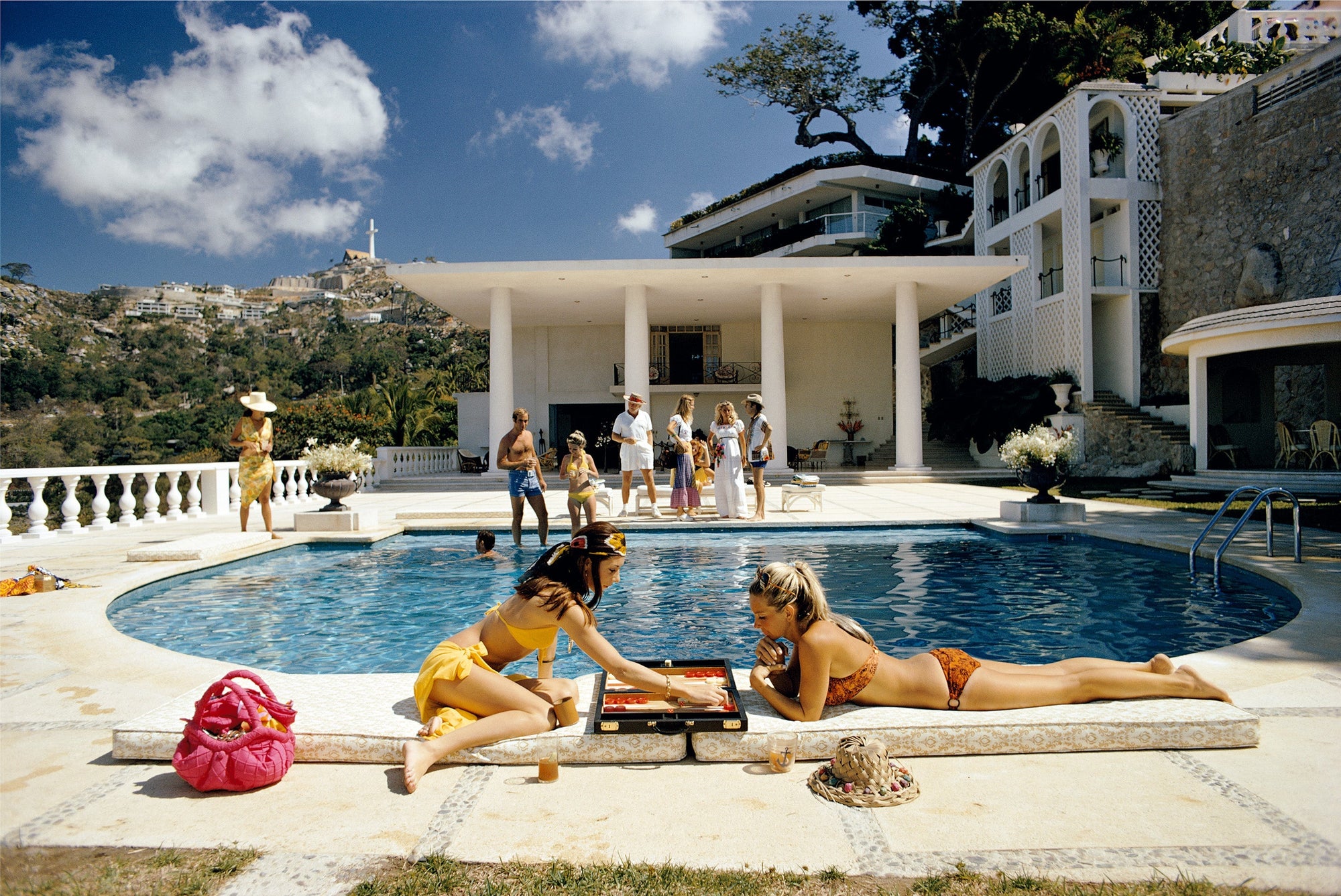 Poolside Backgammon by Slim Aarons/Getty Images, 1972. Open Edition C-Type Photographic Print. Landscape orientation. Available at Electric Gallery, London, UK.