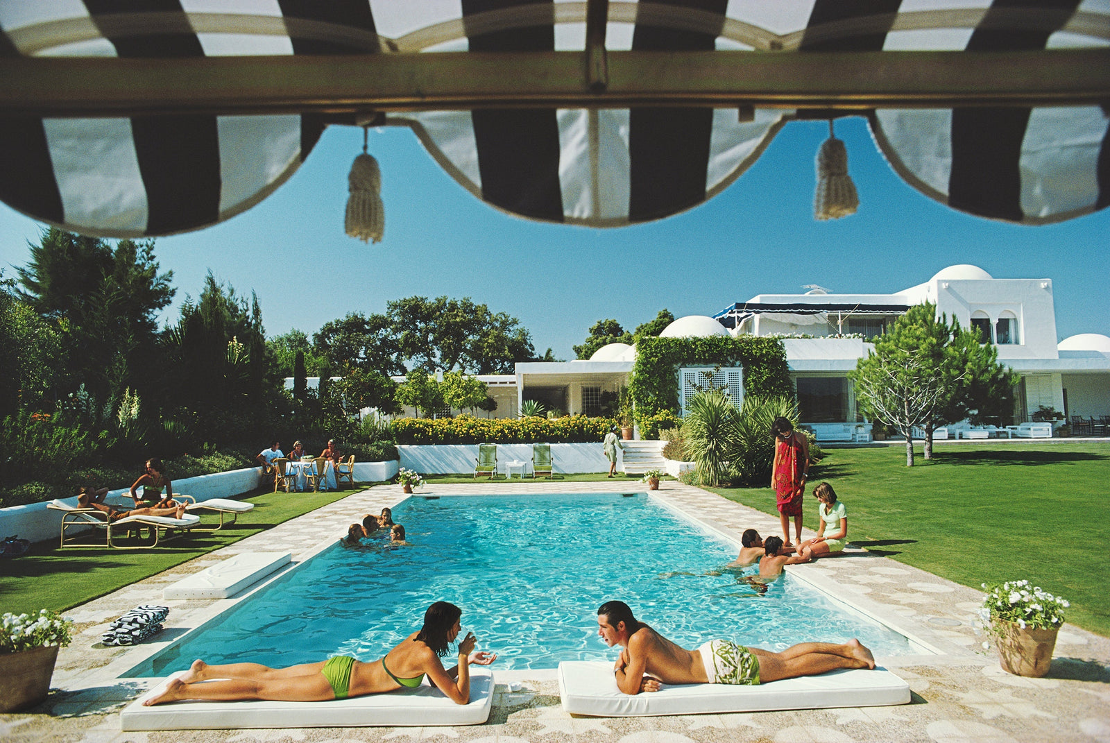 Poolside In Sotogrande by Slim Aarons/Getty Images, 1975. Open Edition C-Type Photographic Print. Landscape orientation. Available at Electric Gallery, London, UK.