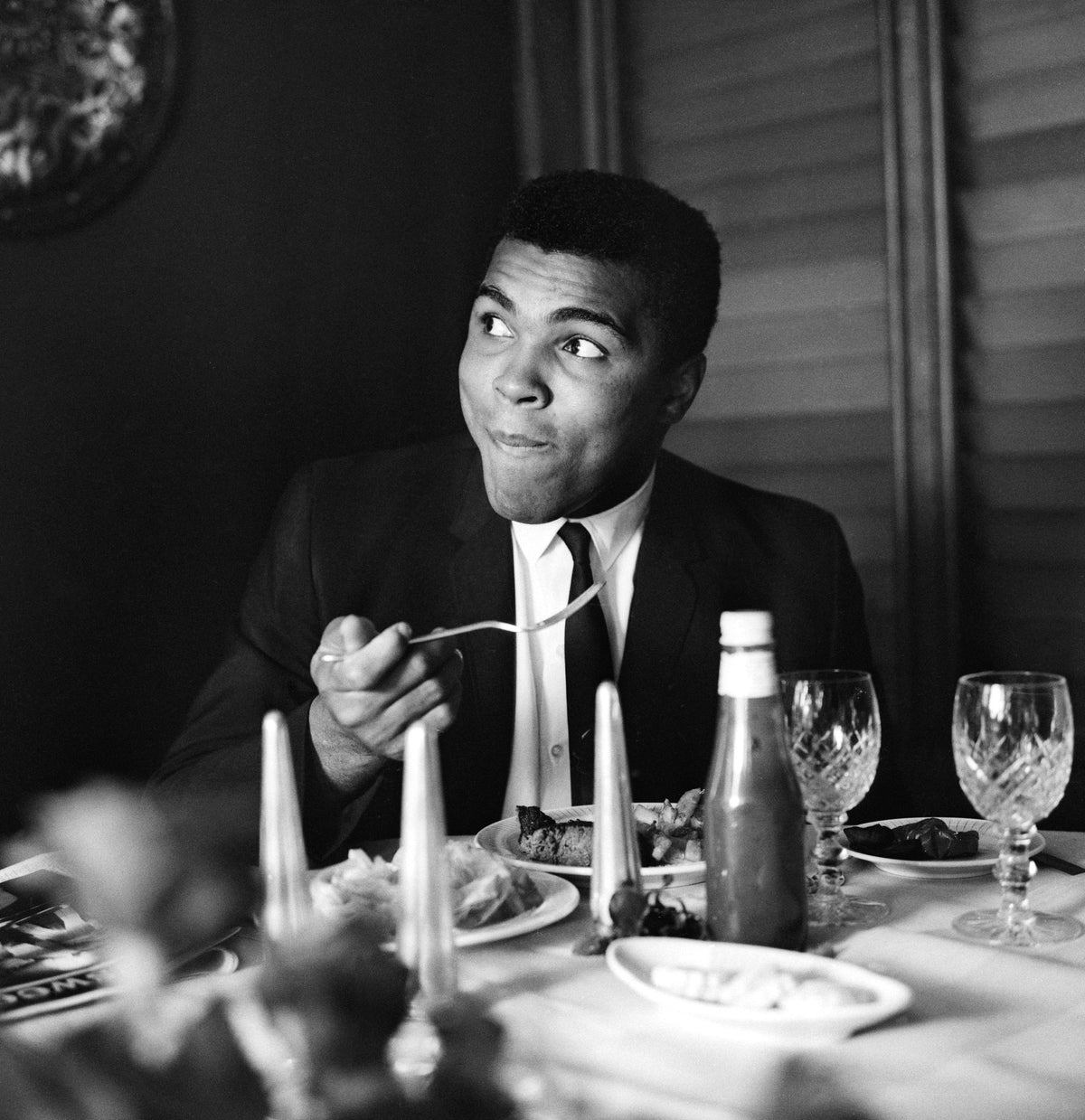 Muhammad Ali by Terry Fincher/Getty Images, 1965. World heavyweight boxing champion Muhammad Ali enjoys supper in a restaurant.. Open Edition C-Type Photographic Print. Square orientation. Available at Electric Gallery, London, UK.