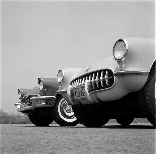 Black and white photograph of a Chevrolet Corvette and Ford Thunderbird parked side by side, 1957
