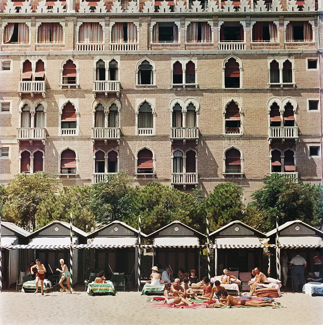 Hotel Excelsior by Slim Aarons/Getty Images, 1957. The beach front of the luxurious Excelsior Hotel on the Venice Lido. Open Edition C-Type Photographic Print. Square orientation. Available at Electric Gallery, London, UK.