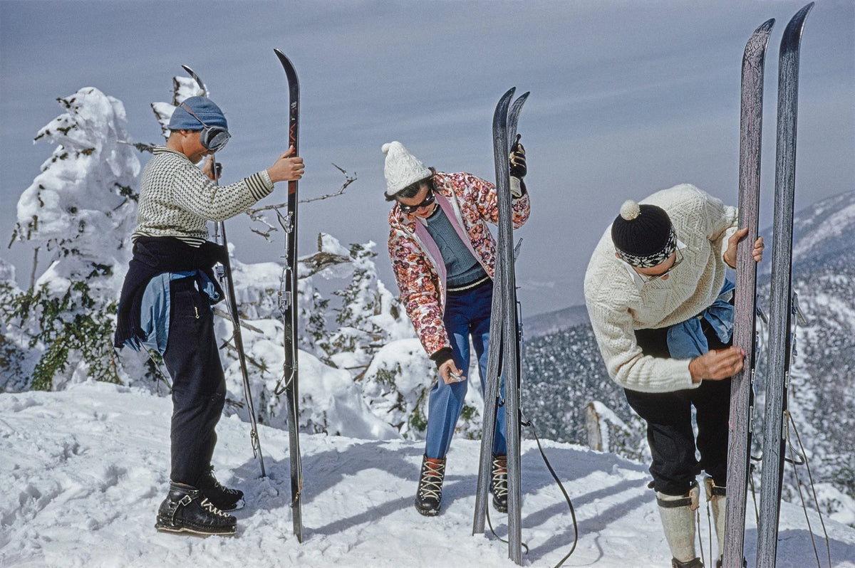 Three skiers inspecting their skis on the slopes of the Sugarbush Mountain ski resort in Warren, Vermont, USA, circa 1960. The Sugarbush resort is one of the largest ski resorts in New England. Slim Aarons photograph.