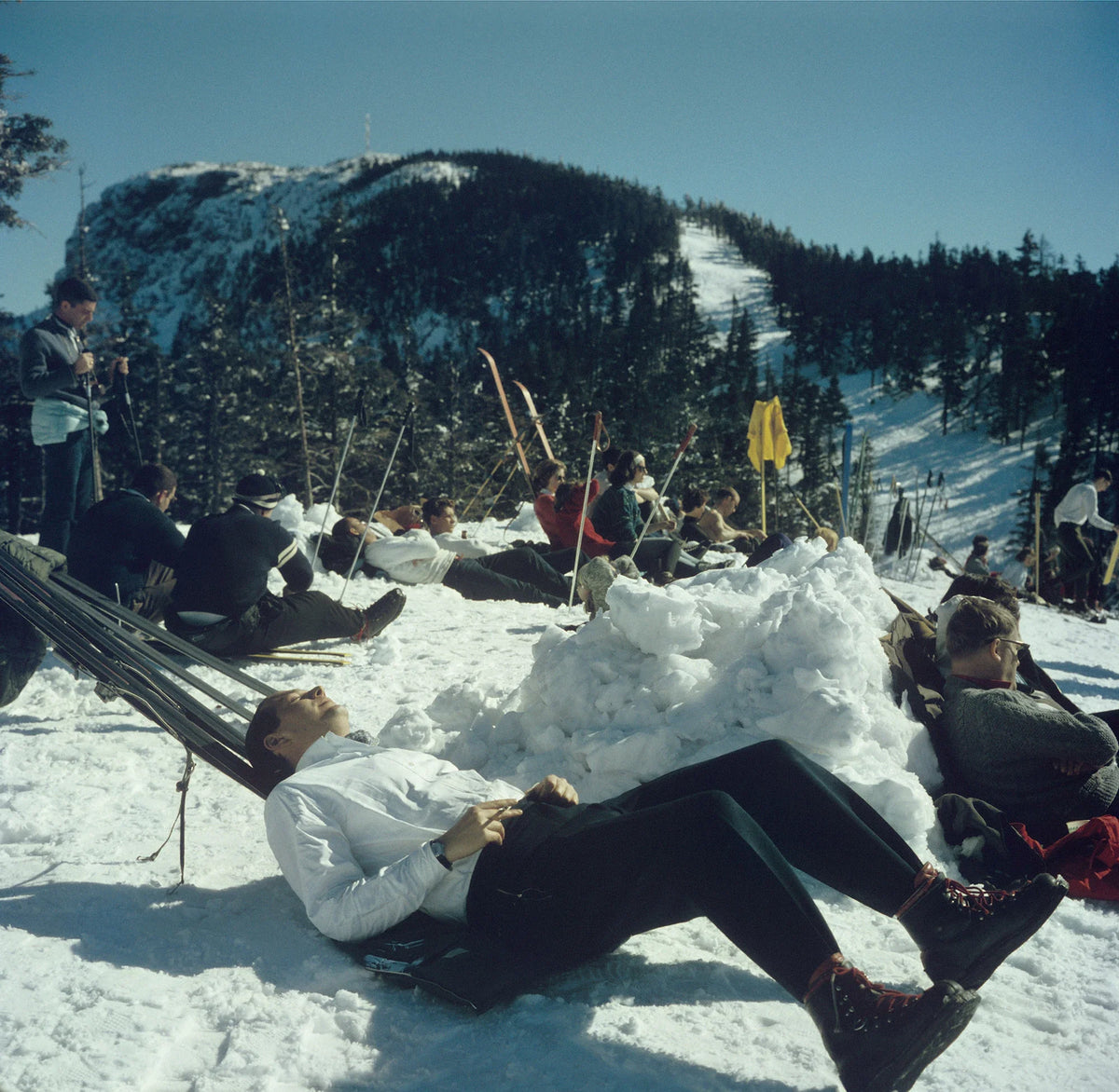 Skiers relaxing on the slopes of the Sugarbush Mountain ski resort in Warren, Vermont, USA, circa 1960. The Sugarbush resort is one of the largest ski resorts in New England. Slim Aarons photograph.