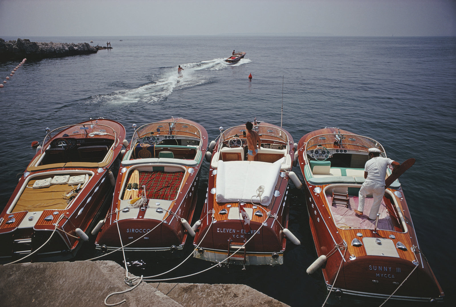 Hotel du Cap Eden-Roc (Boats) by Slim Aarons/Getty Images, 1969. Waterskiing from the Hotel Du Cap-Eden-Roc in Cap d'Antibes, France. Open Edition C-Type Photographic Print. Landscape orientation. Available at Electric Gallery, London, UK.
